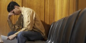 Stressed man sitting in waiting room